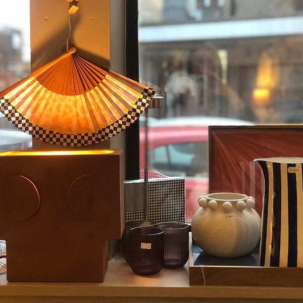 Etalage van de winkel: brandende waaierlamp, vazen en gekleurde glazen