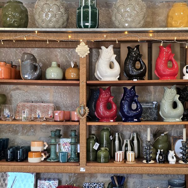 Pichets poissons, vases et bougeoirs colorés dans les rayons de la boutique