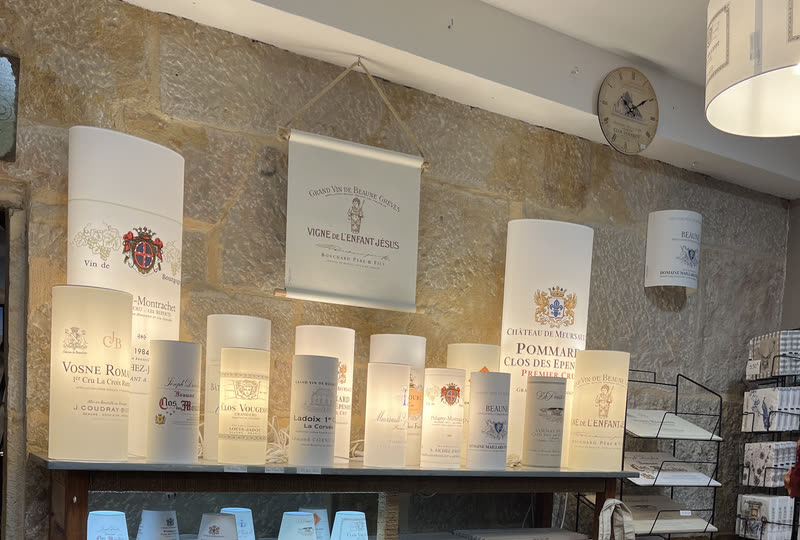 Lampes à étiquettes allumées sur un mur de pierre, au magasin de Beaune